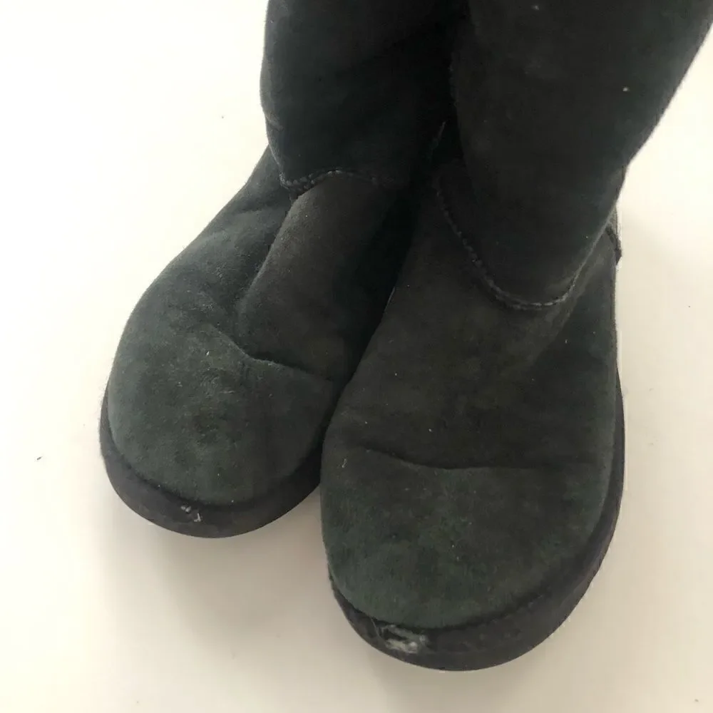 Ugg’s classic tall boots in black shearling lined